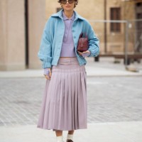 Irina Kro Eicke wears lavender midi skirt with attachable pleated part, matching top with buttons, blue jacket and brown mini bag outside the Bally...