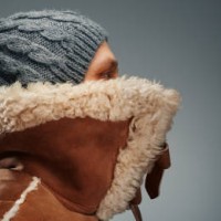 it's so cold. man wearing leather coat with fur collar and knit hat - fashion stock pictures, royalty-free photos & images