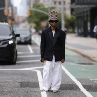 Jalil Johnson is seen wearing a large striped hat in black and natural hemp, from Esenshel, black butterfly-shaped sunglasses, dangling earrings with...