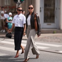 Janka Polliani is seen wearing black narrow cat-eye sunglasses from Balenciaga, several silver hoop earrings and stud earrings, a white cropped shirt...