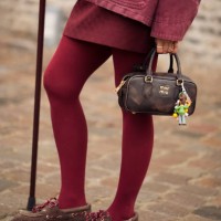 Janka Polliani wears burgundy jacket, burgundy skirt, burgundy tights, brown shoes, brown Miu Miu bag outside the Munthe fashion show during the...