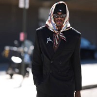 Jarred Vanderbilt is seen wearing a multicolored “Forever Scarf 90” in silk twill with horse prints from Hermès around his head, a black New Era cap...