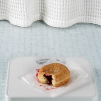 jelly donut on a bathroom scale - junk food stock pictures, royalty-free photos & images