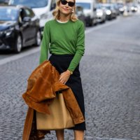 Jenny Walton wears green jumper, high waisted black skirt, white pointed heels outside Carven during the Womenswear Spring/Summer 2024 as part of...