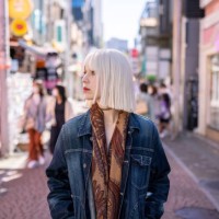 jeune femme aux cheveux blond platine marchant dans la rue commerçante - fashion photos et images de collection