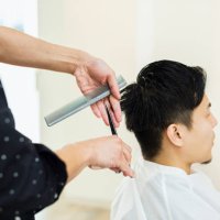 jonge volwassen mannelijke hair stylist eigenaar snijden man's haar - hairstyle stockfoto's en -beelden
