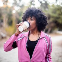 jonge zwarte vrouw lopen met koffie - coffee stockfoto's en -beelden
