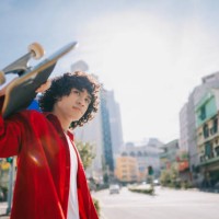 joven malayo asiático que lleva patineta cruzando la calle de la ciudad el fin de semana por la mañana - fashion fotografías e imágenes de stock