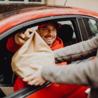 joyful delivery man delivering an order - food stock pictures, royalty-free photos & images