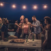 joyful friends having a dinner party during the night on a terrace. - junk food stock pictures, royalty-free photos & images