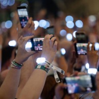 July 2024, North Rhine-Westphalia, Gelsenkirchen: Spectators film with their smartphones during singer Taylor Swift's concert in the Veltins Arena....