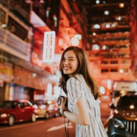 junge, fröhliche asiatin, die nachts vor den neonlichtern hongkongs auf den straßen zurückblickt, während sie ihre kamera hält - travel stock-fotos und bilder