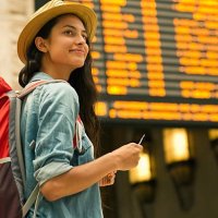 junge frau überprüft ihren zug in zeittafel - travel stock-fotos und bilder