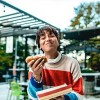 junge frau essen hot dog auf der straße - fashion stock-fotos und bilder