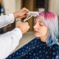 junge frau mit gefärbten haaren, die beim friseur einen haarschnitt bekommt - hairstyle stock-fotos und bilder