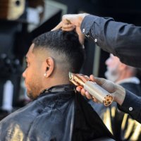 junger mann mit einem haarschnitt in einem friseurgeschäft - hairstyle stock-fotos und bilder