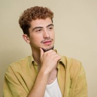 junger mann mit lockigem haar, tief in gedanken versunken - hairstyle stock-fotos und bilder