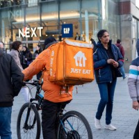 Just Eat takeaway delivery cycle courier cycling along the pavement on 14th December 2023 in Birmingham, United Kingdom. Just Eat acts as an...