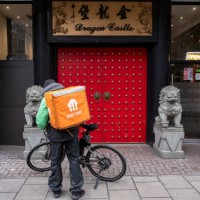 Just Eat takeaway delivery cycle courier outside the Dragon Castle Chinese restaurant on 7th January 2024 in London, United Kingdom. Just Eat acts as...