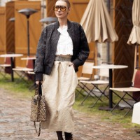 Justyna Czerniak wears beige long skirt, white crop top, black leather jacket, animal print bag, orange sunglasses and animal print shoes outside the...