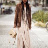Karen Blanchard wears beige long maxi dress with slits, brown suede jacket with tassels, yellow bandana, sunglasses and beige bag outside the Akris...