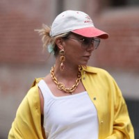 Karin Teigl seen wearing Andy Wolf light blue transparent pilot sunglasses, red / white baseball cap, gold earrings and statement chain necklace,...