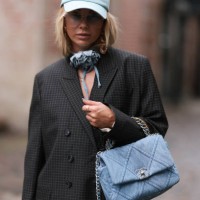 Karin Teigl seen wearing Munthe grey checked blazer jacket with matching suit pants, Sporty & Rich light blue cap, gold pendant earrings, Andy Wolf...