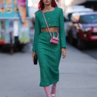 Kate Applepie is seen wearing a pink beanie from Kangol; a green tow-piece-suit, consisting of a cropped long-sleeved jacket with pink heart shaped...