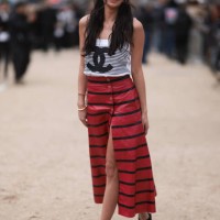 Kelsey Merritt seen wearing a black and white striped Chanel top, black and red striped long skirt, black Chanel ballerinas and a mini brown and...
