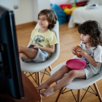 kids eating in front of a television - junk food stock pictures, royalty-free photos & images