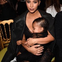 Kim Kardashian and baby North West attend the Givenchy show as part of the Paris Fashion Week Womenswear Spring/Summer 2015 on September 28, 2014 in...