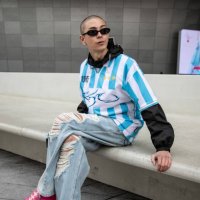 Kim Seong-ju wears a blue striped soccer jersey from Ajobyajo and pink sneakers from Nike x Jaquemus at Seoul Fashion Week AW 23 on March 17, 2023 in...