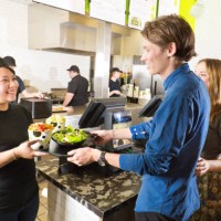 kitchen and wait staff serving customers in fast food restaurant - junk food stock pictures, royalty-free photos & images