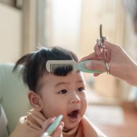 kleiner süßer asiatischer junge, der seinen ersten haarschnitt bekommt - hairstyle stock-fotos und bilder