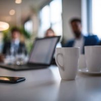 koffie mokken en smart phone op vergadertafel - coffee stockfoto's en -beelden