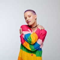 kurzhaarige frau mit regenbogenpullover - fashion stock-fotos und bilder