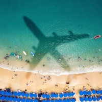 l’ombre de l’avion sur une plage bondée - travel photos et images de collection