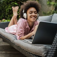 la femme se détend et utilise un ordinateur portable dans la cour arrière - garden decoration photos et images de collection