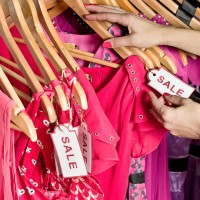 lady picking out dresses with a sale tag on it - fashion stock pictures, royalty-free photos & images