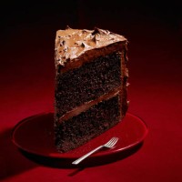 large slice chocolate cake on red background - junk food stock pictures, royalty-free photos & images