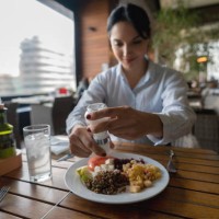 latin american woman enjoying a healthy meal at the hotel restaurant - food stock pictures, royalty-free photos & images