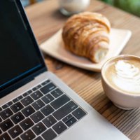 latte kunstkoffie met laptopcomputer en croissant op koffielijst - coffee stockfoto's en -beelden