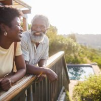 laughing couple standing on the balcony of their luxury vacation rental - travel stock pictures, royalty-free photos & images
