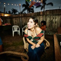 laughing woman sitting in backyard with friends during party on summer evening - garden decoration stock pictures, royalty-free photos & images
