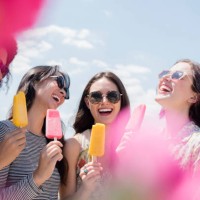 laughing women eating flavored ice outdoors - food stock pictures, royalty-free photos & images