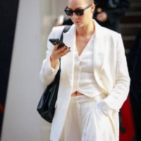 Lauren Burns wearing black sunglasses and white suit during the Australian Fashion Week Presented By Pandora 2024 at Carriageworks on May 13, 2024 in...