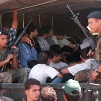 Lebanese army soldiers take away members of the South Lebanese Army who surrendered in the village of Beit Yahoun 22 May 2000. More than 200 SLA...