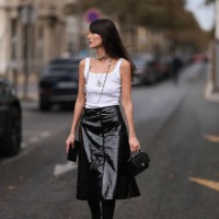 Leia Sfez is seen outside Chanel show wearing silver and black Chanel necklaces, white tank top and black wide patent skirt and black leather handbag...