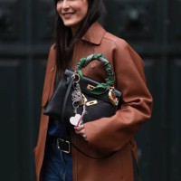 Leia Sfez is seen wearing a brown leather Hermes jacket, blue denim jeans, black belt and Hermes black bag with Kelly twilly charms outside Hermes...