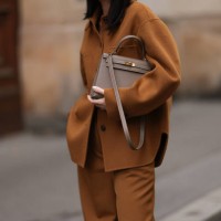 Leo Eberlin is seen wearing a brown two-piece from Arket, consisting of a jacket with dark brown button placket, collar, and large chest pockets, a...